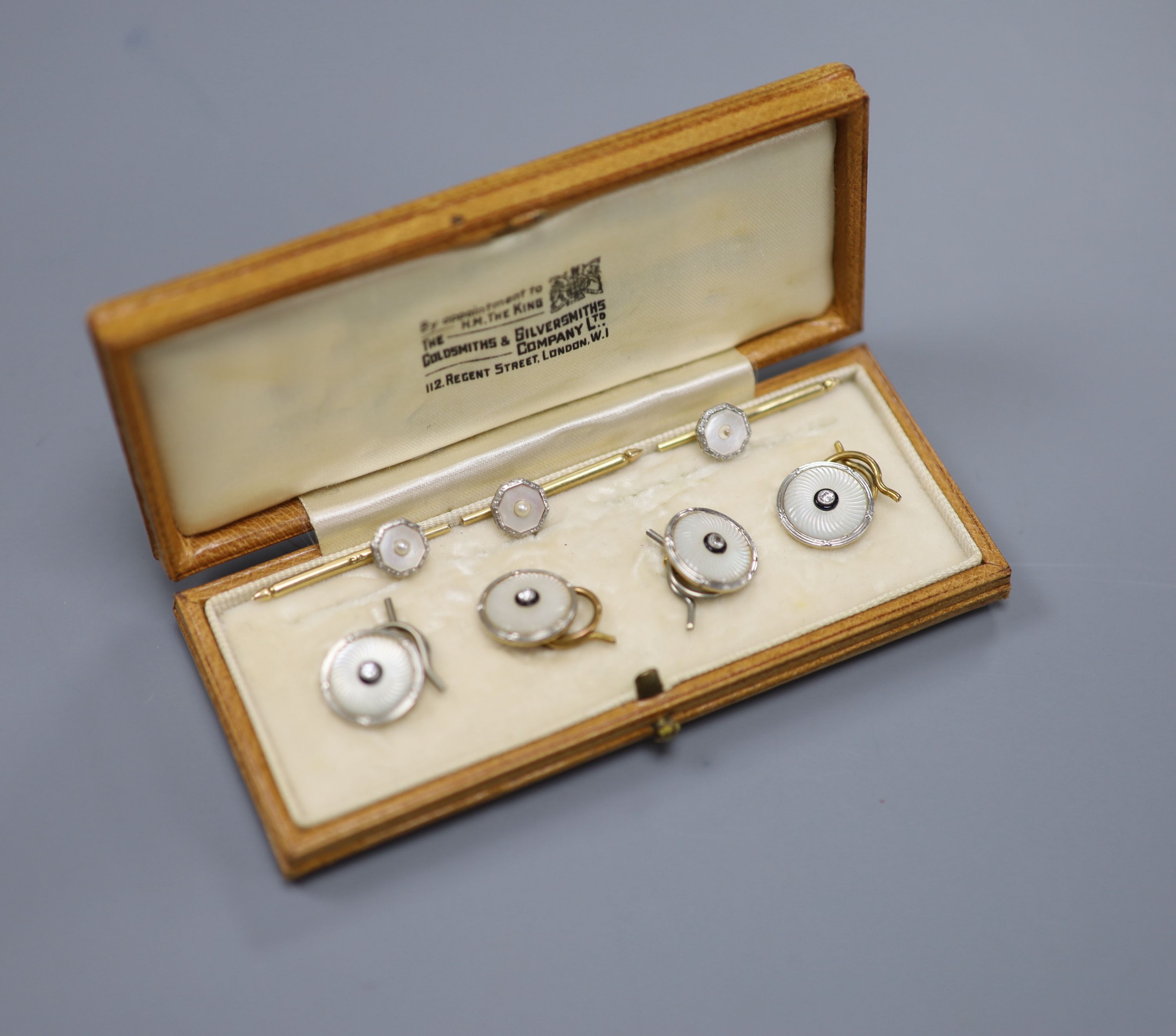 A cased set of four 1940s 18ct & Pt, mother of pearl and diamond set dress studs and three others.